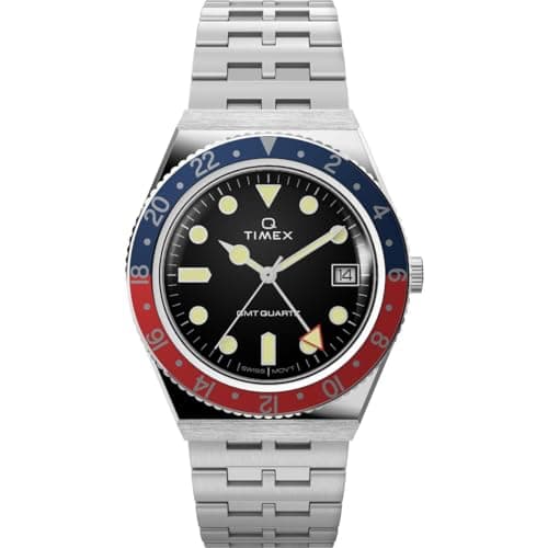 Q Timex Armbanduhr mit schwarzem Zifferblatt, blau-roter Lünette und Edelstahlarmband vor weißem Hintergrund